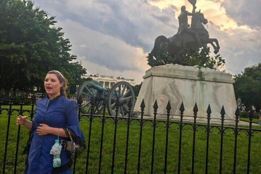 A person standing in front of a statue with a cannon in the background. 1