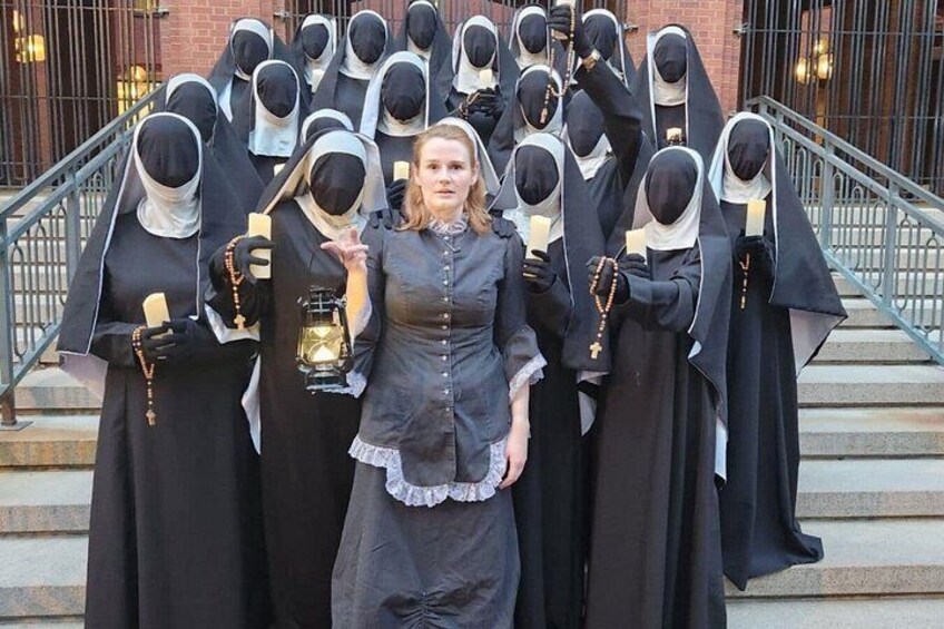 A group of individuals in black religious attire standing on steps. 2