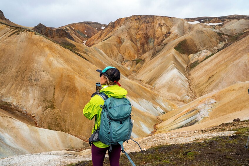 Een wandelaar in bergachtig terrein met duidelijke geologische formaties. 5