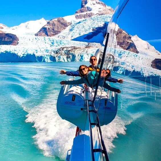 A person on a boat with a glacier and mountains in the background. 1