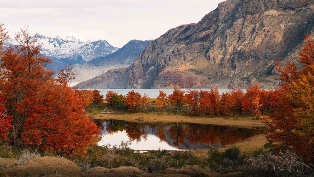 A lake surrounded by autumn-colored trees and mountains. 2