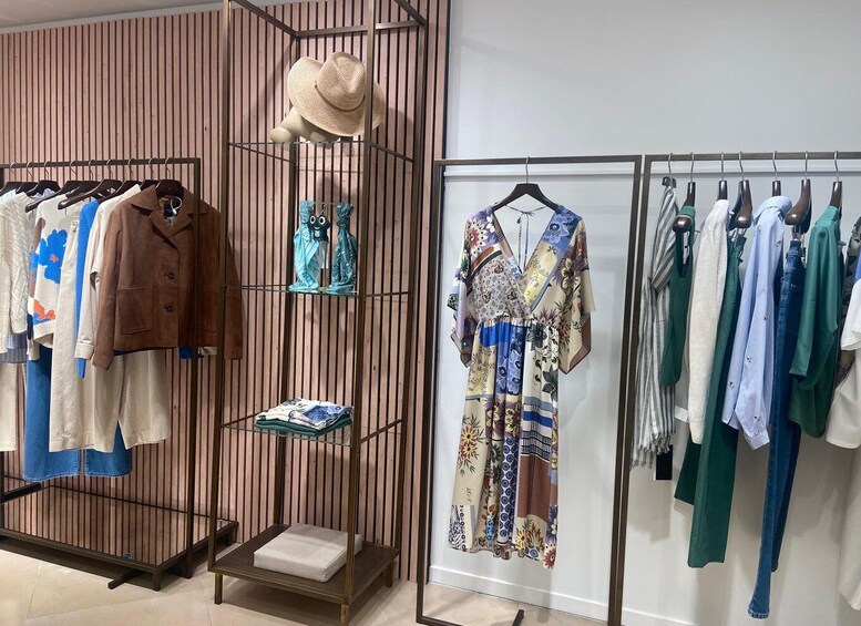 A clothing store with racks of shirts, dresses, and accessories. 5