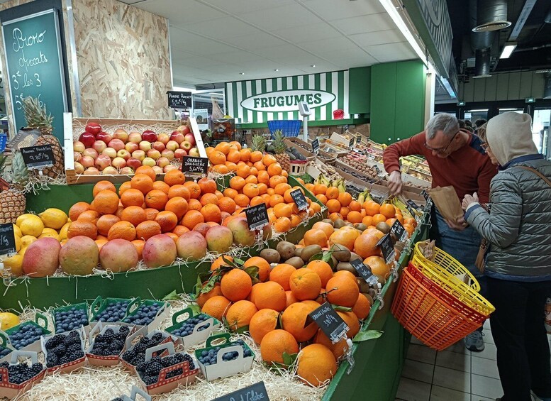 A grocery store's fruit section with various fruits like oranges, apples, and blueberries on display. 2