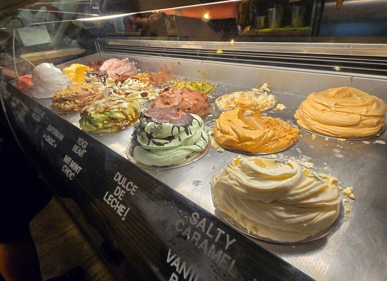A dessert display with various ice cream flavors and toppings. 3