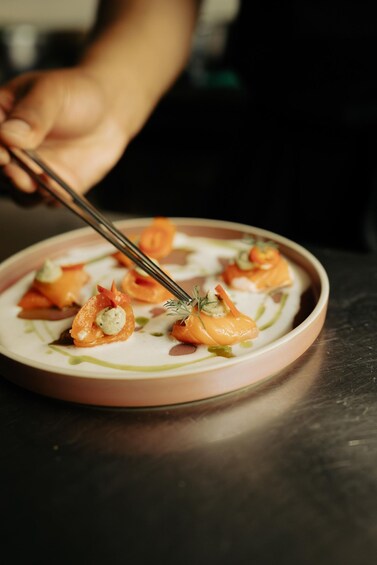 A plate of food with salmon and garnishes. 4