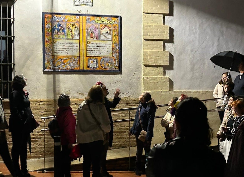 A crowd of people observing a colorful stained glass window. 4