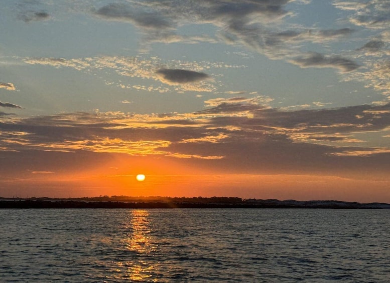 A sunset over a body of water with clouds in the sky. 5