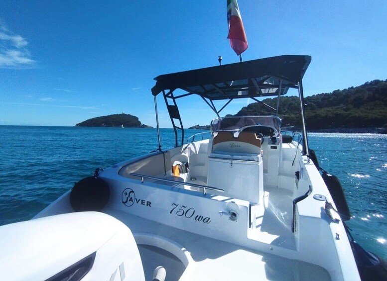 A boat named 'Caver 750' on a clear blue sea with a small island in the background. 2