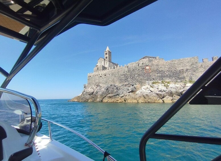 A boat with a view of a historic stone castle on a rocky coastline. 5