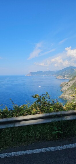 A coastal road with a view of the sea, cliffs, and distant mountains. 2