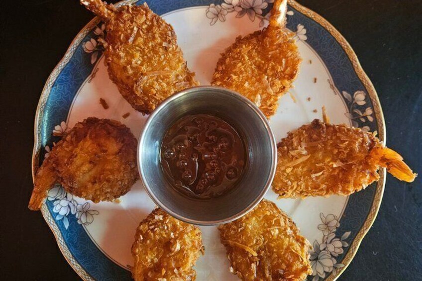 A plate of fried shrimp with a dipping sauce. 3