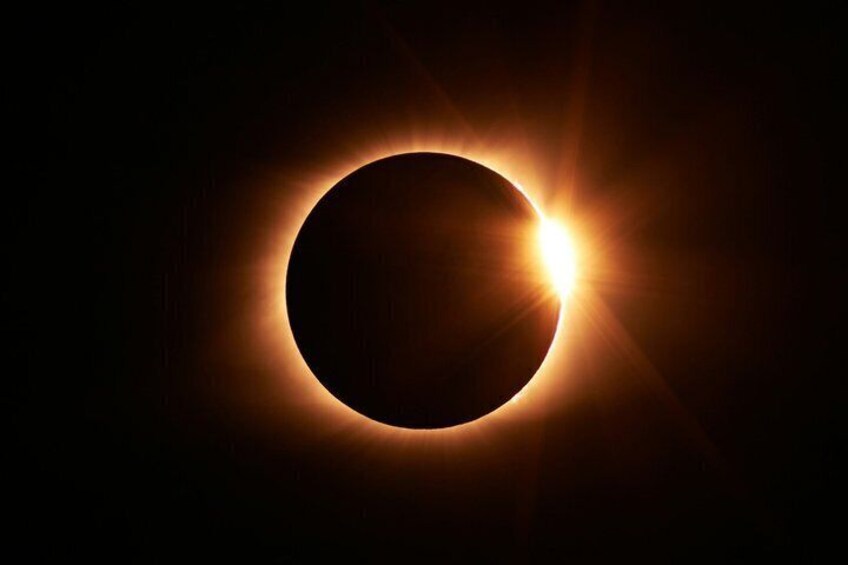 A solar eclipse with the moon covering the sun, creating a bright corona around the edges. 1