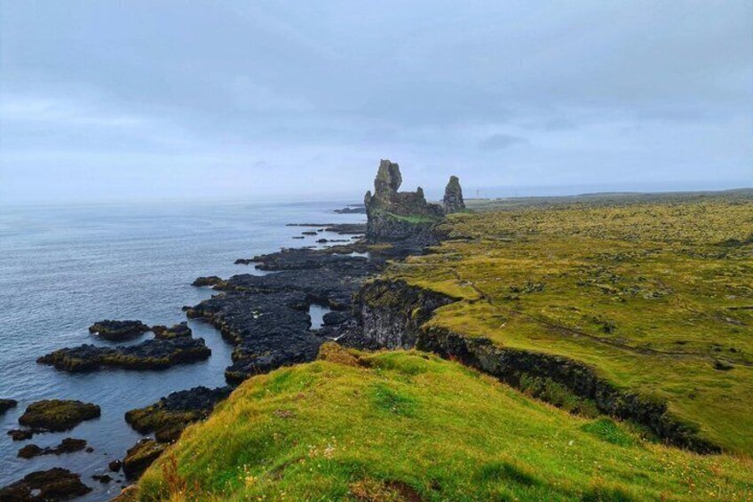 A coastal landscape with rocky outcrops and grassy terrain. 5