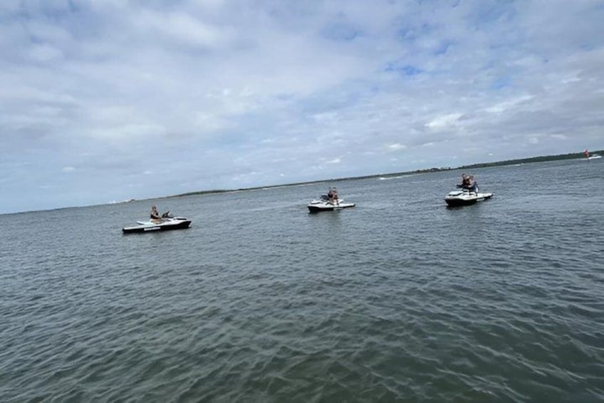 Three small boats on a calm body of water with a cloudy sky. 2