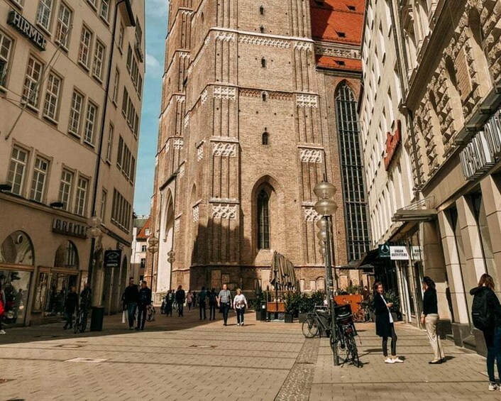 A historic building with intricate brickwork and arched windows, surrounded by pedestrians and bicycles. 4
