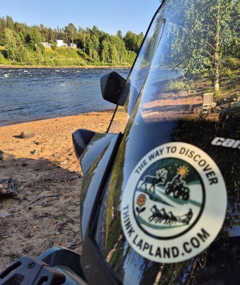 A vehicle with a sticker that reads 'THE WAY TO DISCOVER THINK LAPLAND.COM' and a river in the background. 5