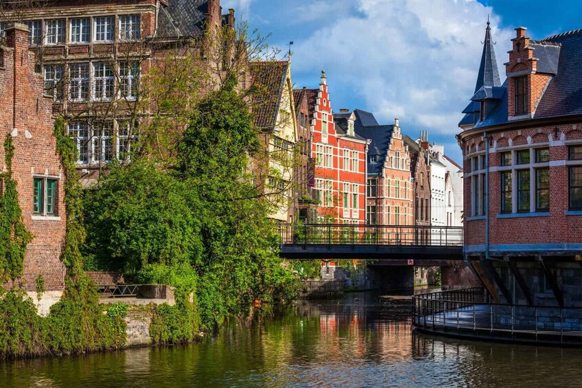 A canal with buildings on either side, a bridge, and a tree in the foreground. 2