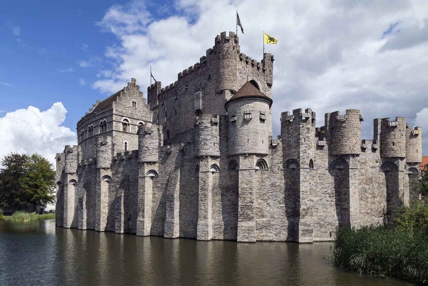 A historic castle with multiple towers, a flag, and a moat. 3