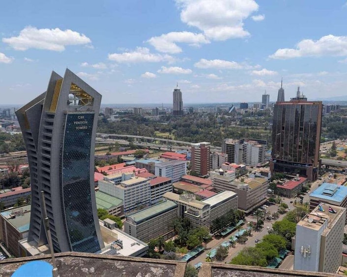 A cityscape with prominent skyscrapers, including the CAIXA PENSION TOWERS, and a bridge in the background. 1