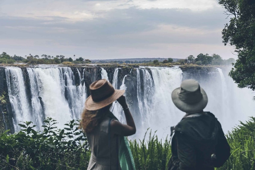 Two people observing a large waterfall. 5