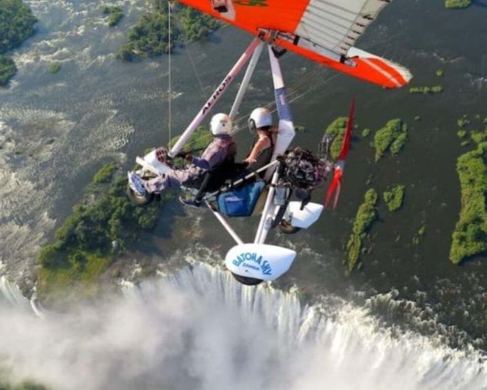 A person skydiving with a parachute over a river. 1