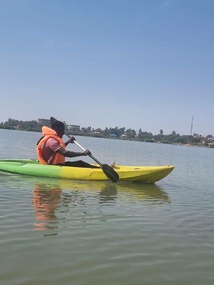 A person kayaking on a calm body of water. 3
