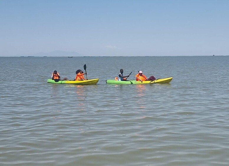 Three people kayaking on a calm body of water with a clear sky. 2