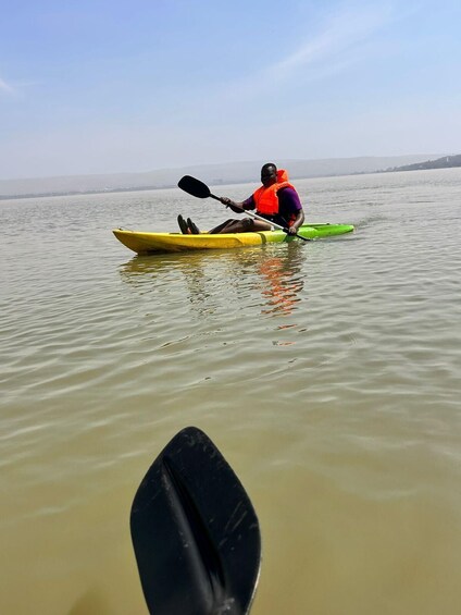 A person kayaking on a calm body of water. 1