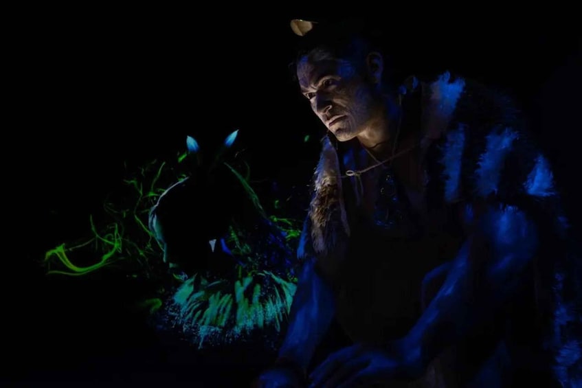 A person in a dark environment with blue and green lighting effects. 1
