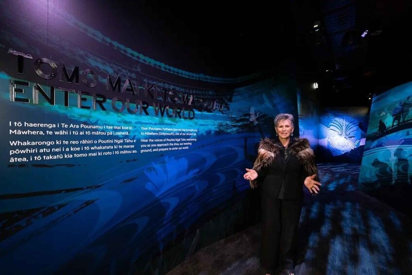 A person standing in front of a wall with text and graphics. 3