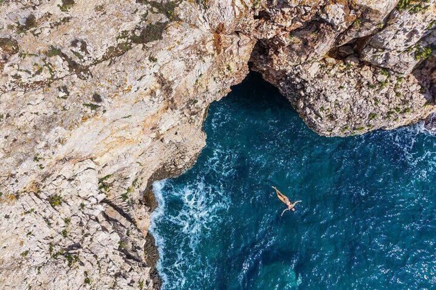Une côte rocheuse où l’on voit une personne plonger dans l’eau. 5