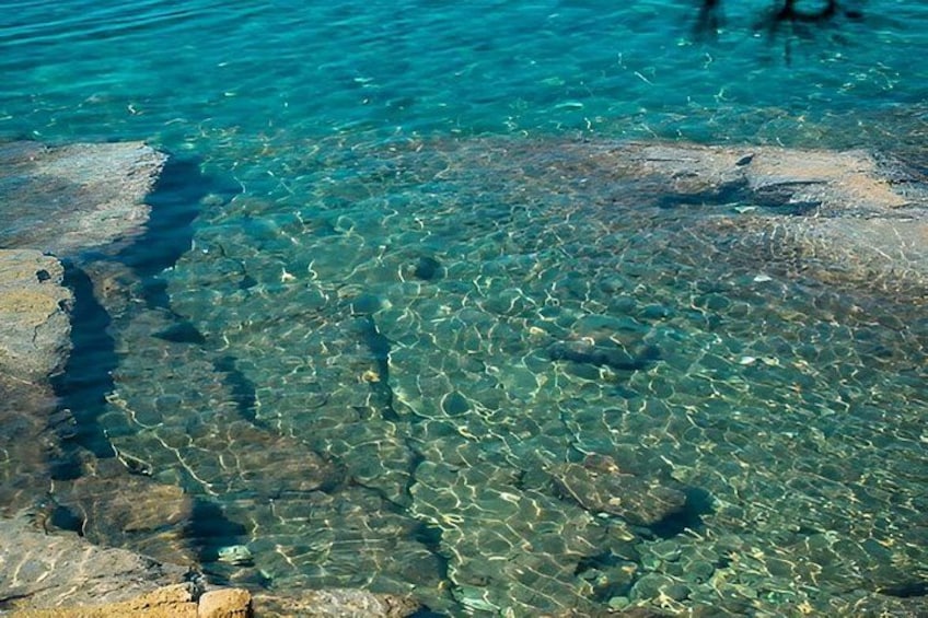 Clear water, rocky surface, and a shadow. 2