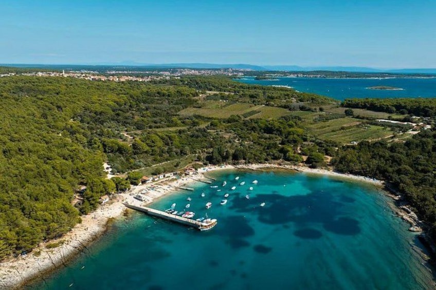 A coastal landscape with a beach, boats, and a pier. 4