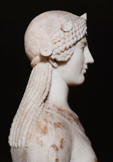 A marble bust with a detailed headdress and draped garment. 2