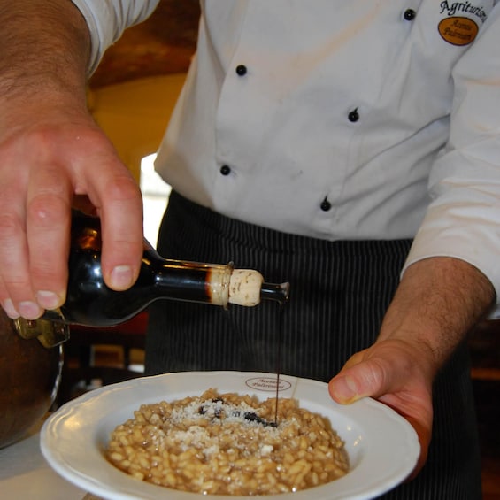 A person pouring a liquid from a bottle into a bowl of food. 3