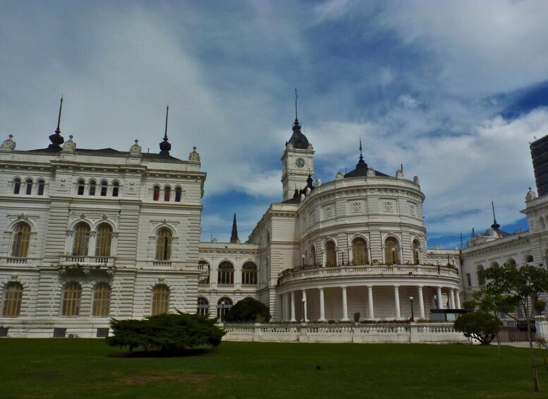 A grand white building with a central tower and a round structure with columns. 1