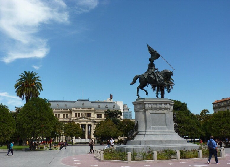 A statue of a figure on horseback in a public square with buildings in the background. 3