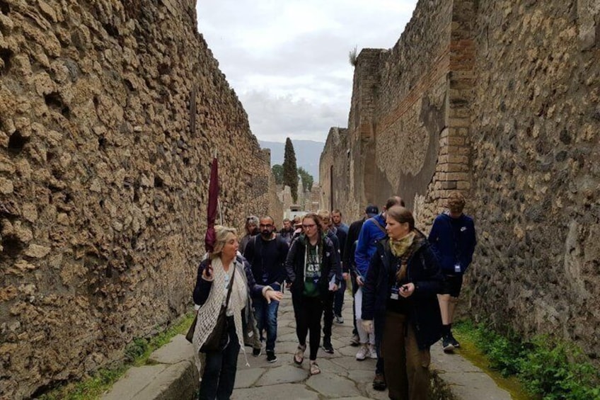 A group of people walking through an ancient stone corridor. 5