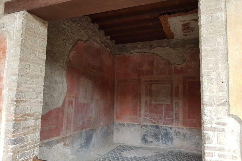 An ancient room with brick walls and a tiled floor. 2