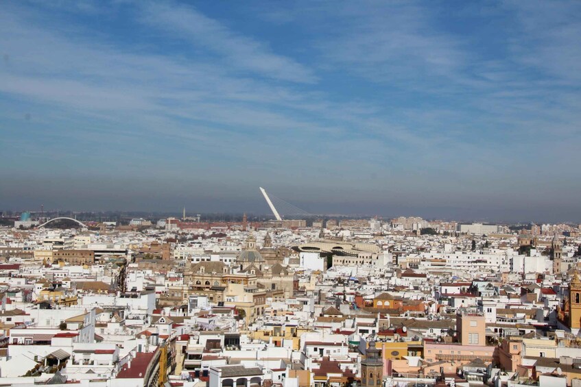 A densely packed cityscape with a prominent white bridge in the distance. 5