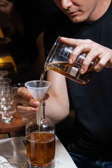 A person pouring a liquid from a measuring cup into a glass. 4