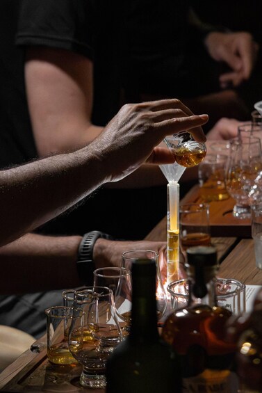 A person pouring a drink into a glass. 3