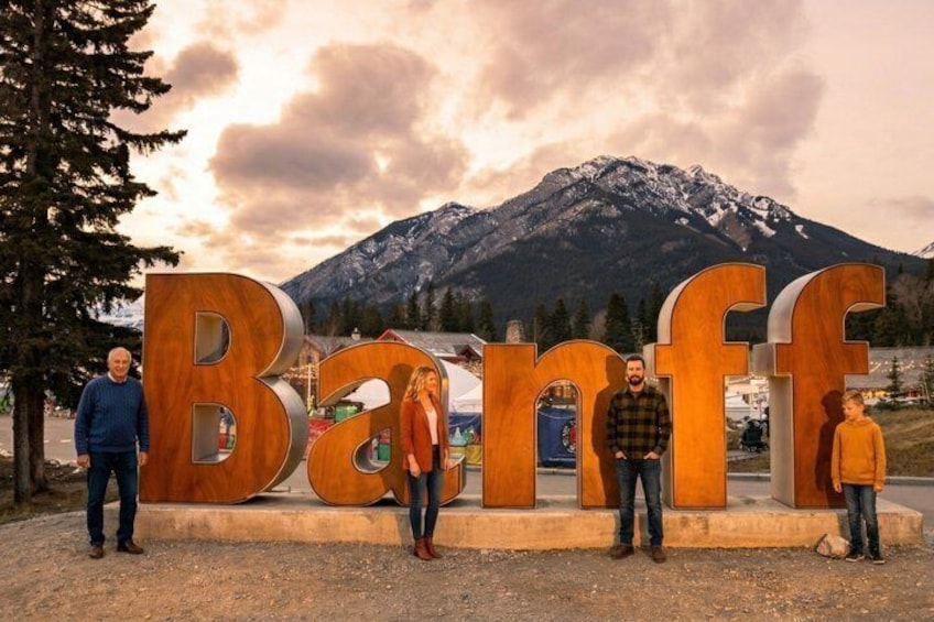 Ett bergigt landskap med stora träbokstäver som tillsammans bildar ordet ”Banff” i förgrunden. 1