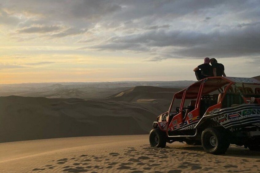 A dune buggy on a desert dune with a cloudy sky. 5