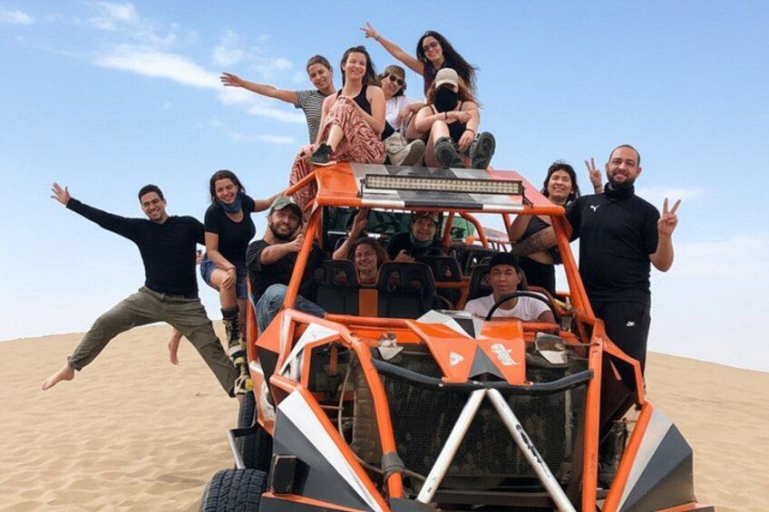 A group of people on a dune buggy in a desert landscape. 2