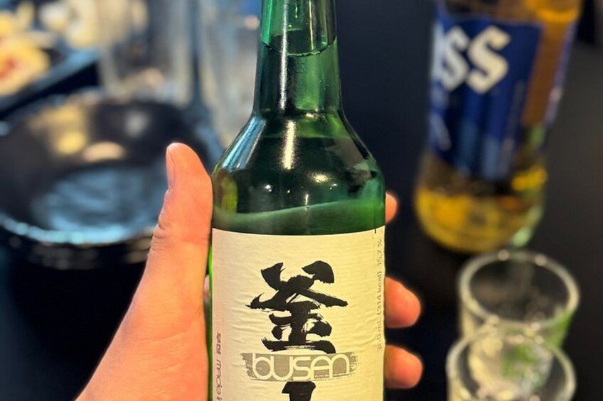 Une main tenant une bouteille dont l’étiquette porte des caractères japonais. 2