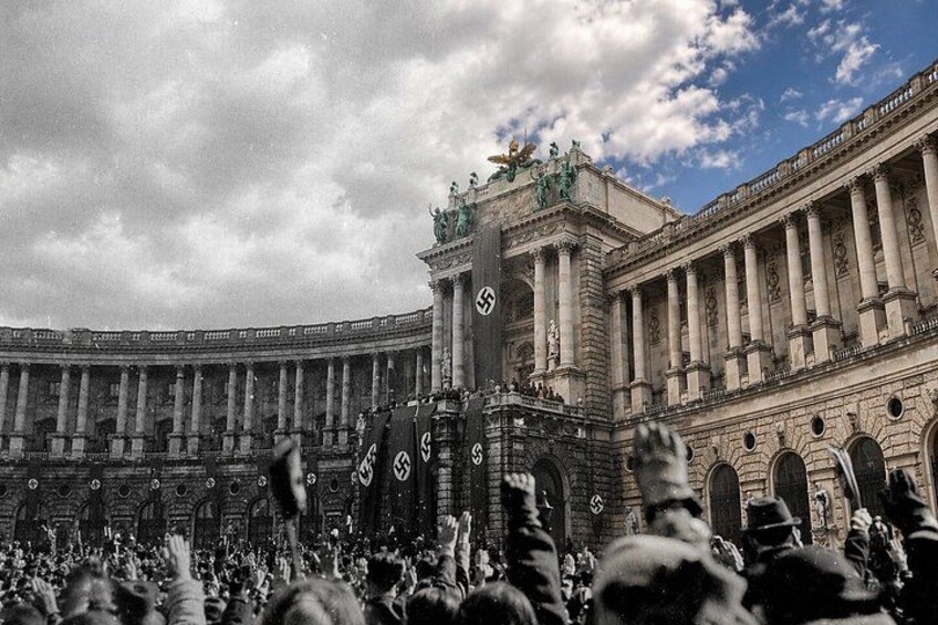 Una multitud grande frente a un edificio imponente con columnas y una estatua en la parte superior. 1