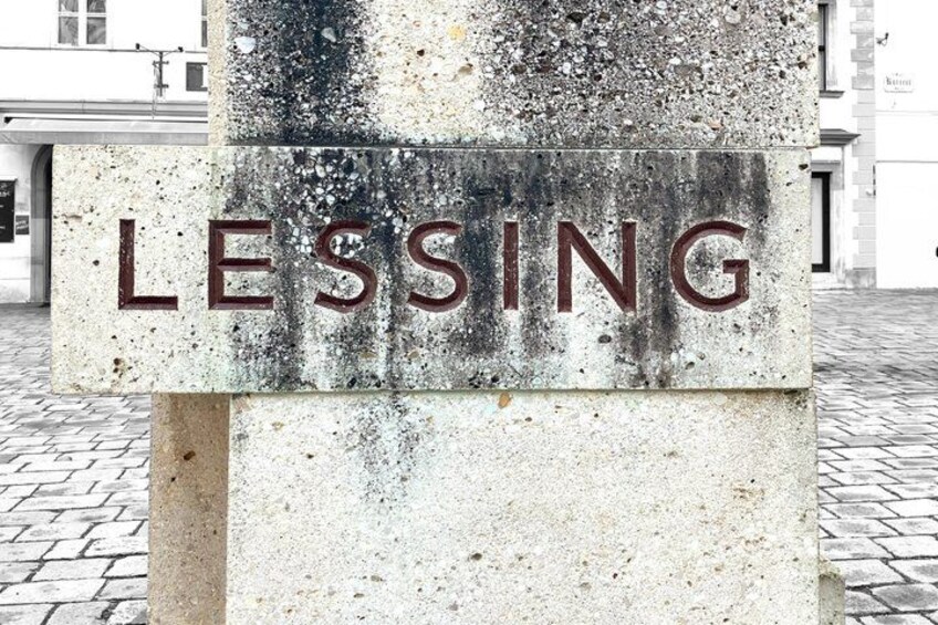 Un monumento de concreto desgastado con la palabra 'LESSING' grabada. 3