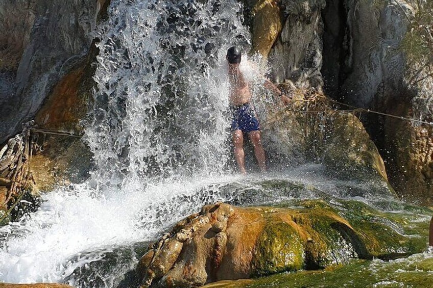 A person standing on a rock with water splashing around them. 3