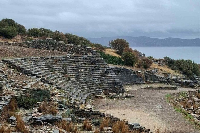 Un ancien amphithéâtre avec des gradins en pierre et une vue sur la mer en arrière-plan. 2